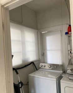 Sheer roller shades fitted in a Studio City laundry room window, providing soft natural light and privacy.