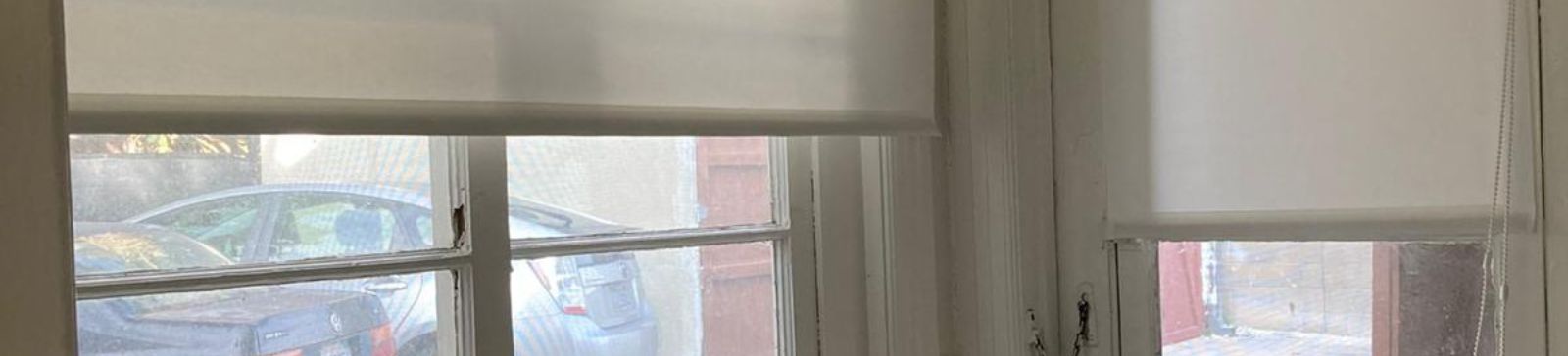 Sheer roller shades fitted in a Studio City laundry room window, providing soft natural light and privacy.