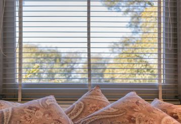 Explore the versatility of mini blinds as they adorn a cozy living room, offering optimal light control and privacy.